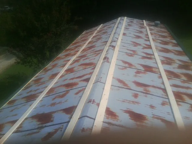 Rusted metal roof panels with new wood purlins before replacement — Storm Damage Roof Repair in Tyler Hill by Roofing Brothers