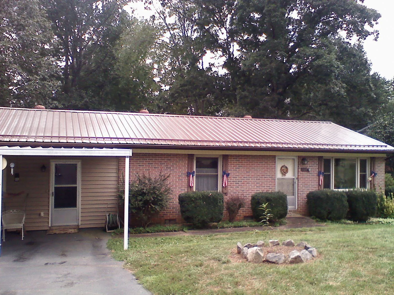 Bronze metal roof and carport on a brick ranch home — Roof Repair work by our crew in Tyler Hill