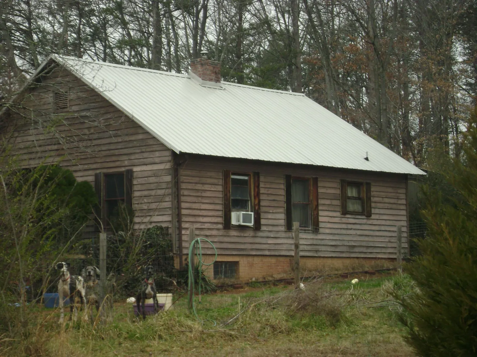 White metal roof on an old wood sided farmhouse, from a Metal Roof Installation job in Tyler Hill